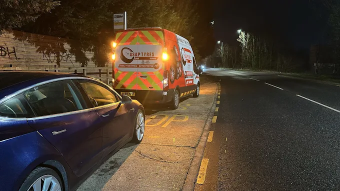 ASAP Tyres 247 van with hazard markings assisting a car at the roadside at night